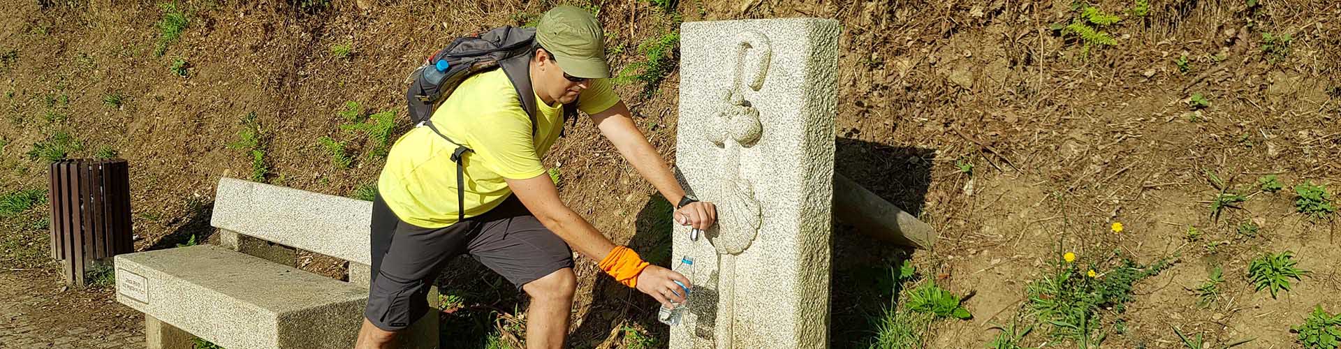 pilgrim refilling water on the way from Tui on the portuguese camino