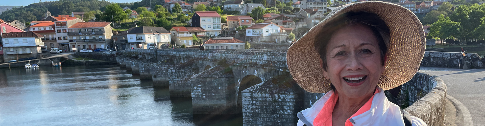 pilgrim with famous bridge along Camino Portugues