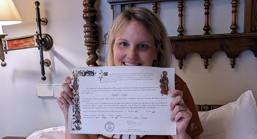 pilgrim holding the compostela certificat of completion of the Camino de Santiago