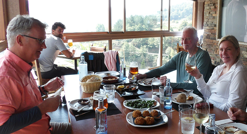 Travelers sitting at a café table in a Spanish town on the Camino
