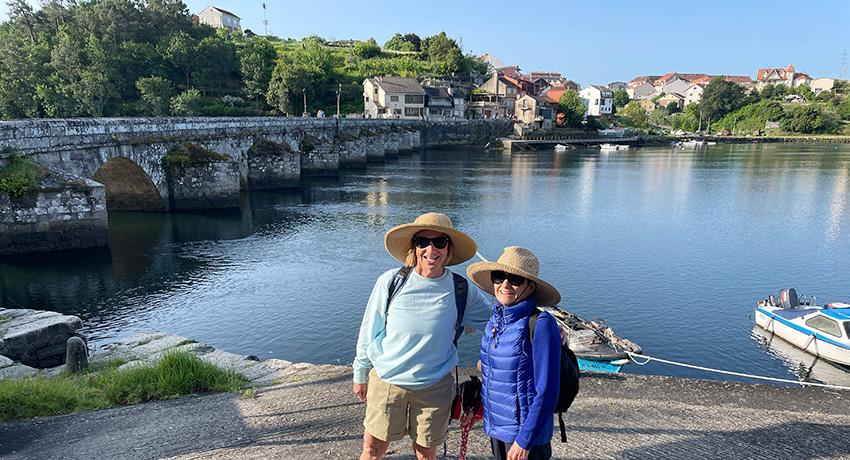 Two lady pilgrims walking el Camino along the waterfront