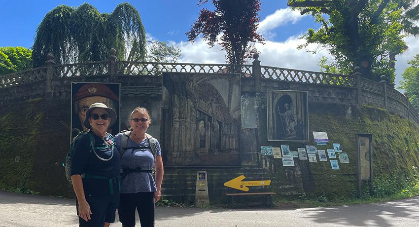 pilgrims by a Camino marker arrow