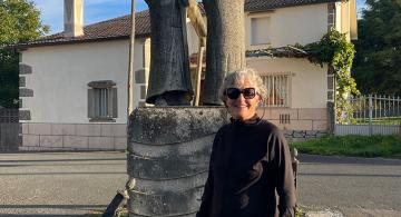 pilgrim posing in front of statues along the Camino de Santiago