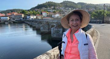 pilgrim smiling on bridge along camino portugues