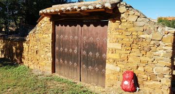 pilgrim backpack laying by a Camino door